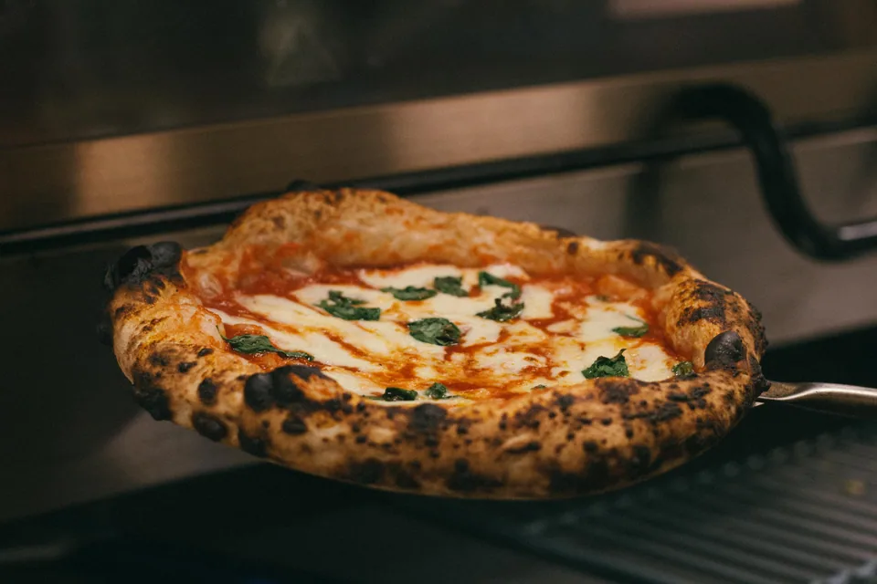 Pizza pizzalapiolla uunin edessä